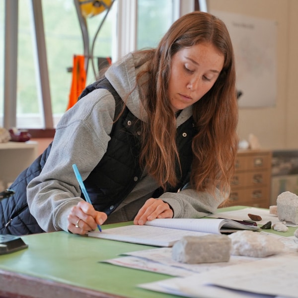 Manitobans working within a testing lab analyzing rock samples